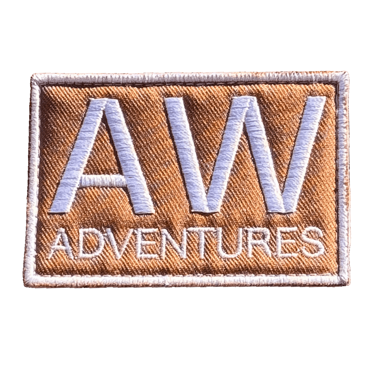 AWA Title embroidered travel patch featuring large white AW lettering above Adventures text on a tan rectangular background.