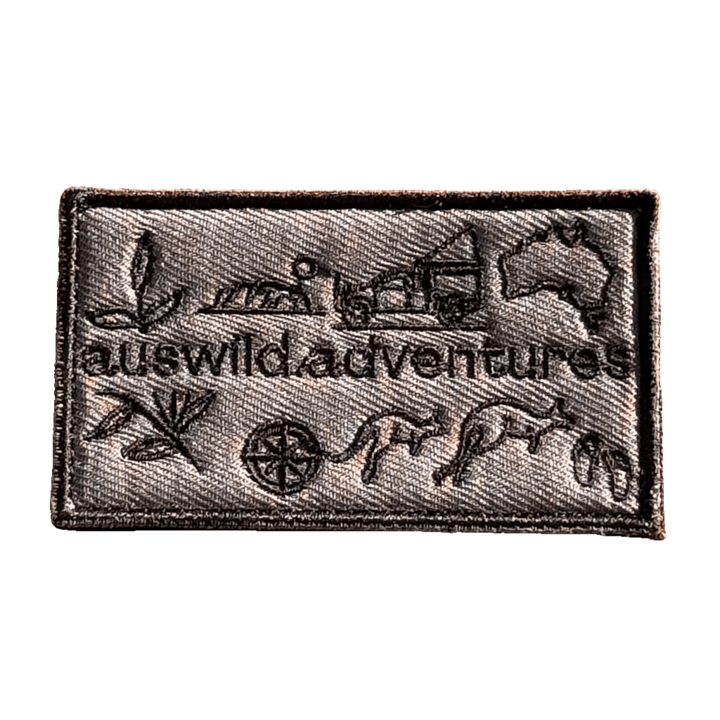 AWA Graphic embroidered travel patch featuring Aus Wild Adventures lettering surrounded by Uluru, a 4WD, kangaroos, compass, gum leaves and an Australia outline.