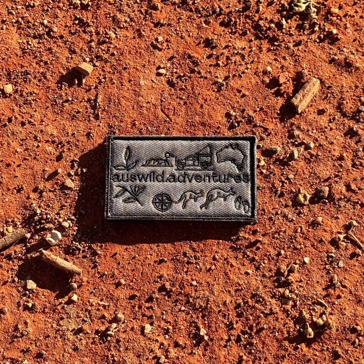 AWA Graphic embroidered travel patch featuring Aus Wild Adventures lettering surrounded by Uluru, a 4WD, kangaroos, compass, gum leaves and an Australia outline.