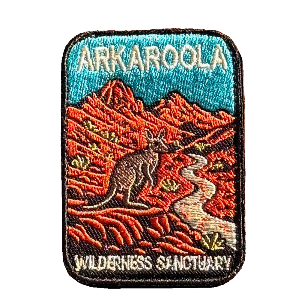 Arkaroola embroidered travel patch featuring kangaroo beside a winding track through rugged red mountains beneath a teal sky.