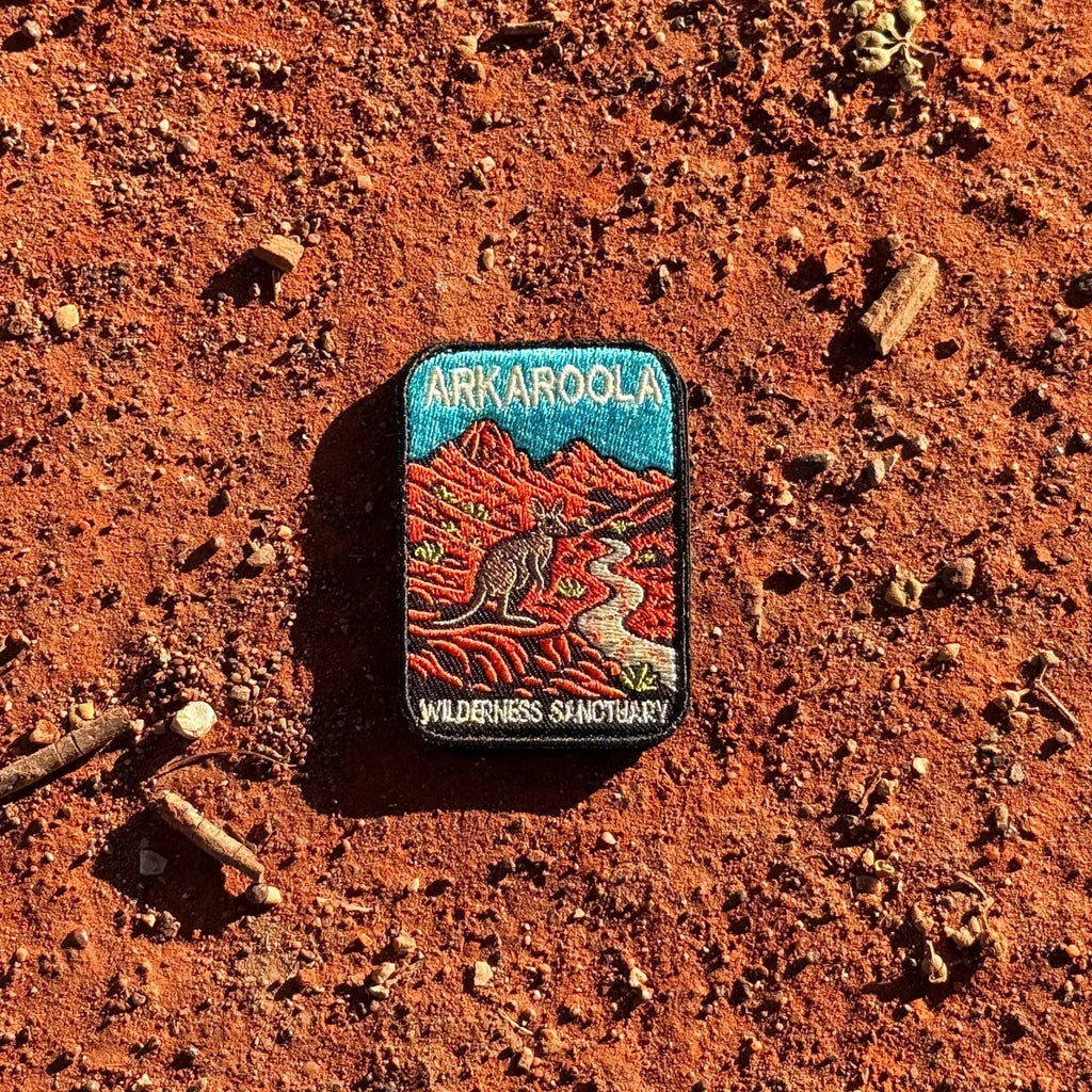 Arkaroola embroidered travel patch featuring kangaroo beside a winding track through rugged red mountains beneath a teal sky.