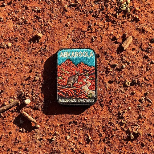 Arkaroola embroidered travel patch featuring kangaroo beside a winding track through rugged red mountains beneath a teal sky.