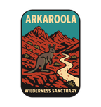 Arkaroola illustrated travel patch design featuring kangaroo beside a winding track through rugged red mountains beneath a teal sky.