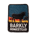 Barkly Homestead embroidered travel patch featuring dark cattle silhouette against orange outback hills and a teal sky.