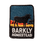 Barkly Homestead embroidered travel patch featuring dark cattle silhouette against orange outback hills and a teal sky.