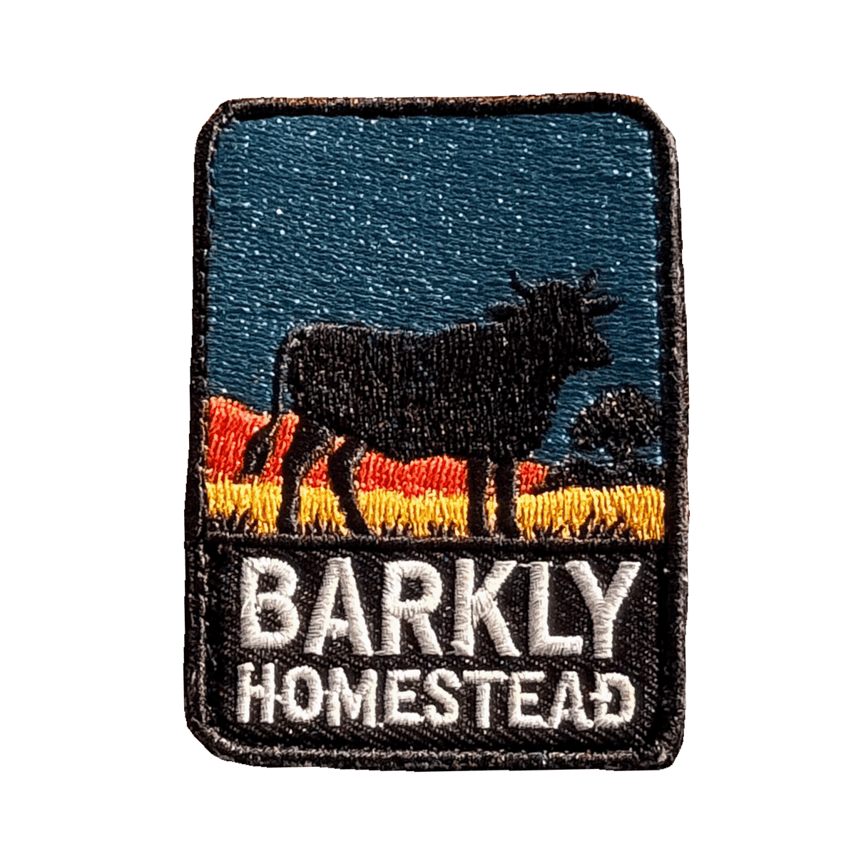 Barkly Homestead embroidered travel patch featuring dark cattle silhouette against orange outback hills and a teal sky.