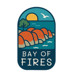 Bay of Fires illustrated travel patch design featuring orange coastal boulders, turquoise ocean, a setting sun and a flying seabird.