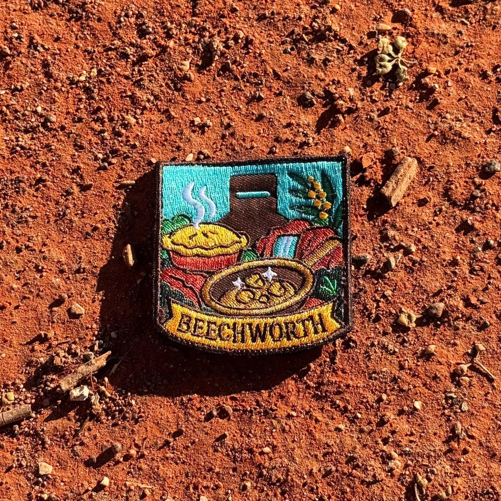 Beechworth embroidered travel patch featuring gold pan, steaming pie, historic chimney, waterfall and native wattle flowers.