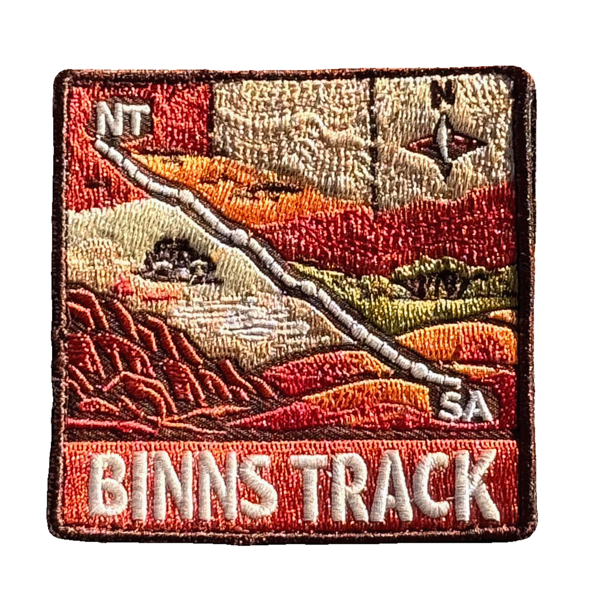 Binns Track embroidered travel patch featuring 4WD and dotted route crossing red desert country between the Northern Territory and South Australia.