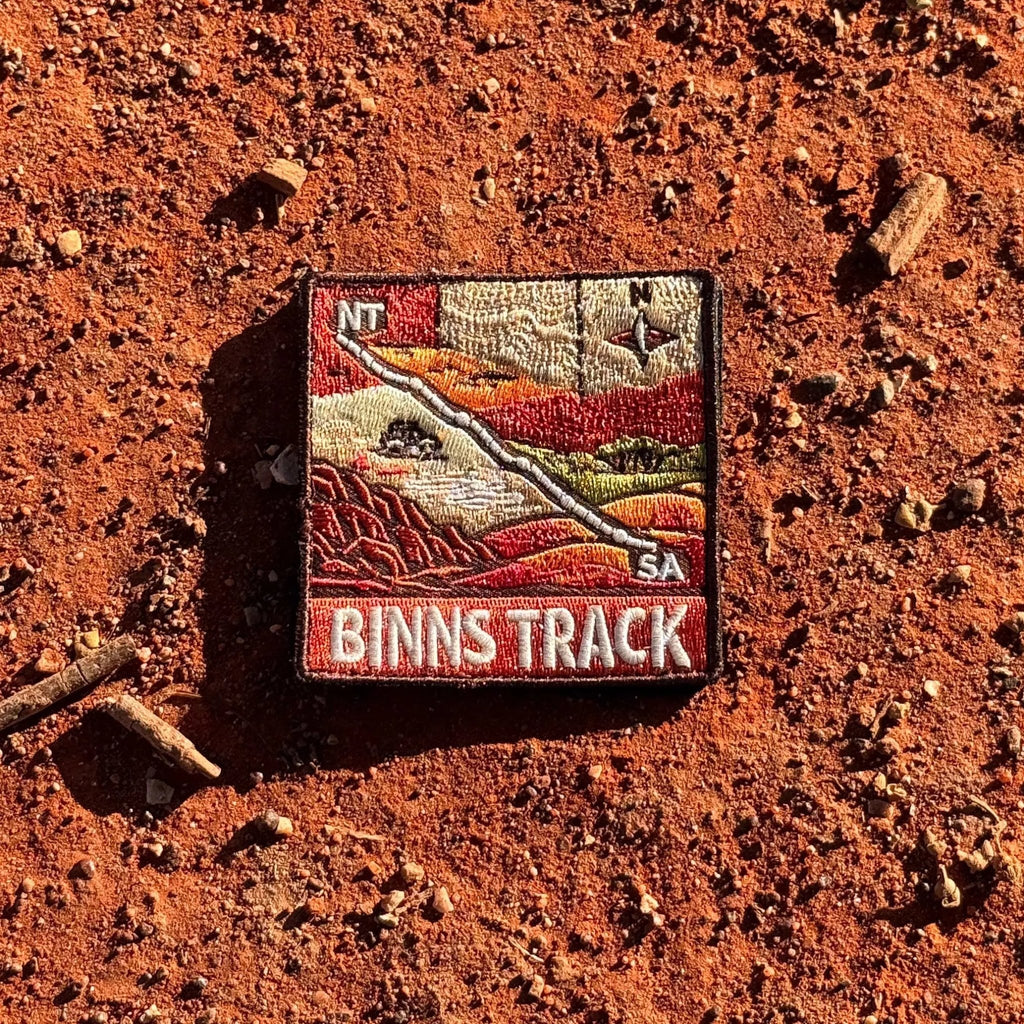 Binns Track embroidered travel patch featuring 4WD and dotted route crossing red desert country between the Northern Territory and South Australia.