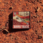Binns Track embroidered travel patch featuring 4WD and dotted route crossing red desert country between the Northern Territory and South Australia.