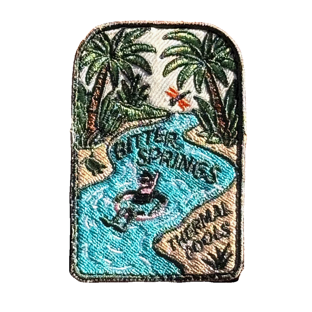 Bitter Springs embroidered travel patch featuring snorkeller floating through turquoise thermal pools surrounded by tropical palms.