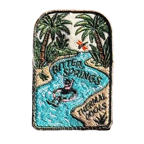 Bitter Springs embroidered travel patch featuring snorkeller floating through turquoise thermal pools surrounded by tropical palms.
