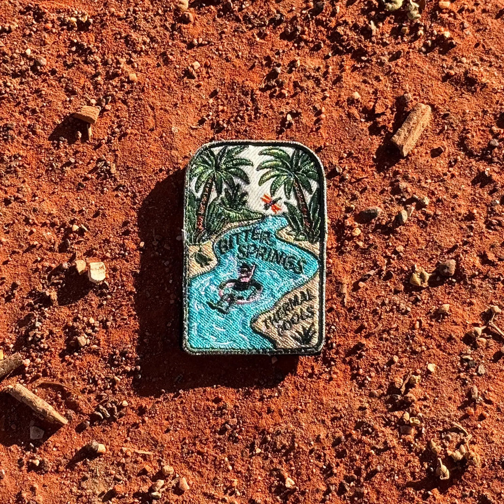 Bitter Springs embroidered travel patch featuring snorkeller floating through turquoise thermal pools surrounded by tropical palms.