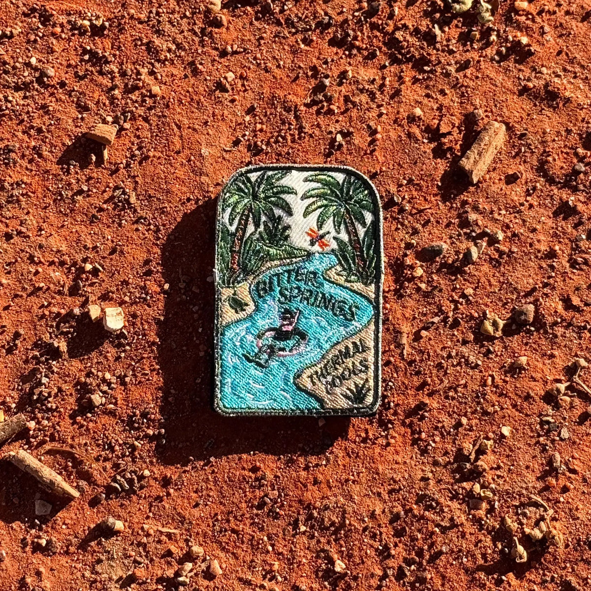 Bitter Springs embroidered travel patch featuring snorkeller floating through turquoise thermal pools surrounded by tropical palms.