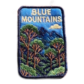 Blue Mountains embroidered travel patch featuring eucalyptus forest, layered blue mountain peaks and a white cloud against a deep blue sky.