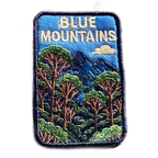 Blue Mountains embroidered travel patch featuring eucalyptus forest, layered blue mountain peaks and a white cloud against a deep blue sky.