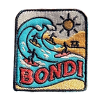 Bondi Beach embroidered travel patch featuring four surfers riding turquoise ocean waves beside a sunny golden beach.