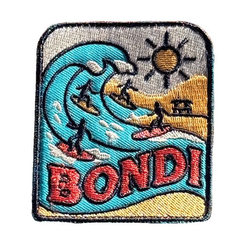 Bondi Beach embroidered travel patch featuring four surfers riding turquoise ocean waves beside a sunny golden beach.