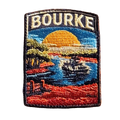 Bourke embroidered travel patch featuring paddle steamer cruising along a winding river through red outback scenery at sunset.