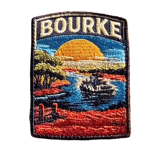 Bourke embroidered travel patch featuring paddle steamer cruising along a winding river through red outback scenery at sunset.