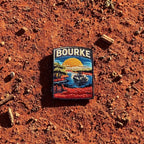 Bourke embroidered travel patch featuring paddle steamer cruising along a winding river through red outback scenery at sunset.