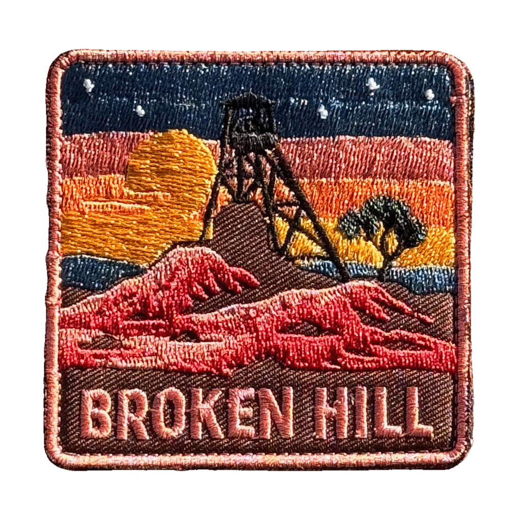 Broken Hill embroidered travel patch featuring historic mining headframe silhouetted against an orange sunset and red rocky outback.