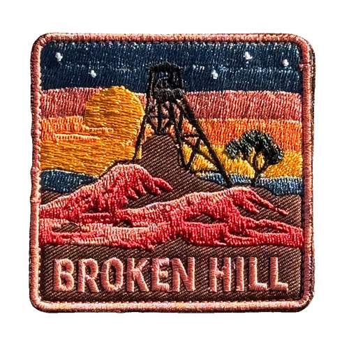 Broken Hill embroidered travel patch featuring historic mining headframe silhouetted against an orange sunset and red rocky outback.