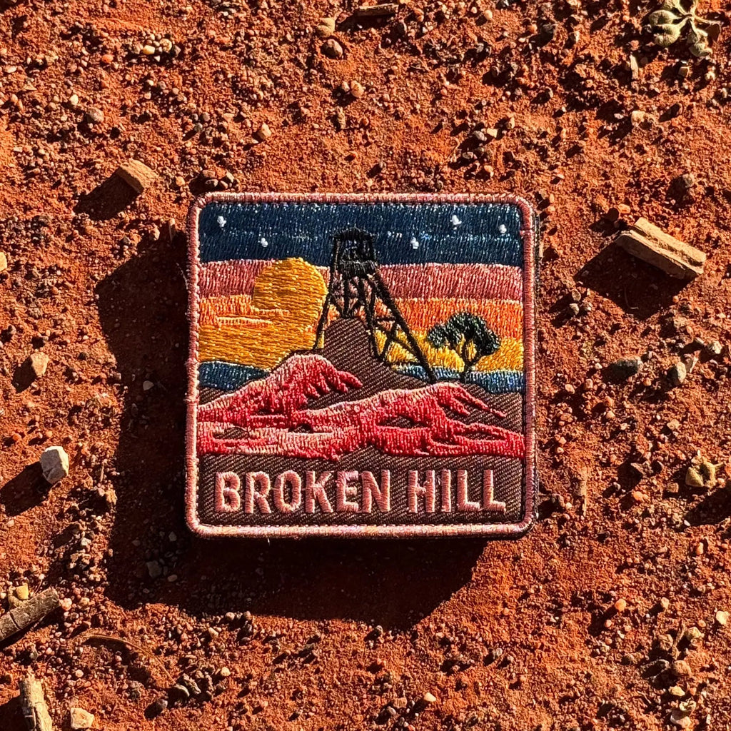 Broken Hill embroidered travel patch featuring historic mining headframe silhouetted against an orange sunset and red rocky outback.
