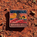 Broken Hill embroidered travel patch featuring historic mining headframe silhouetted against an orange sunset and red rocky outback.