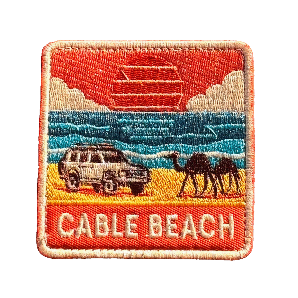 Broome - Cable Beach embroidered travel patch featuring 4WD and two camels on golden sand beside turquoise ocean at sunset.