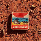 Broome - Cable Beach embroidered travel patch featuring 4WD and two camels on golden sand beside turquoise ocean at sunset.