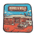 Burke And Wills Roadhouse embroidered travel patch with a remote roadhouse in red outback country; photographed on a transparent background.