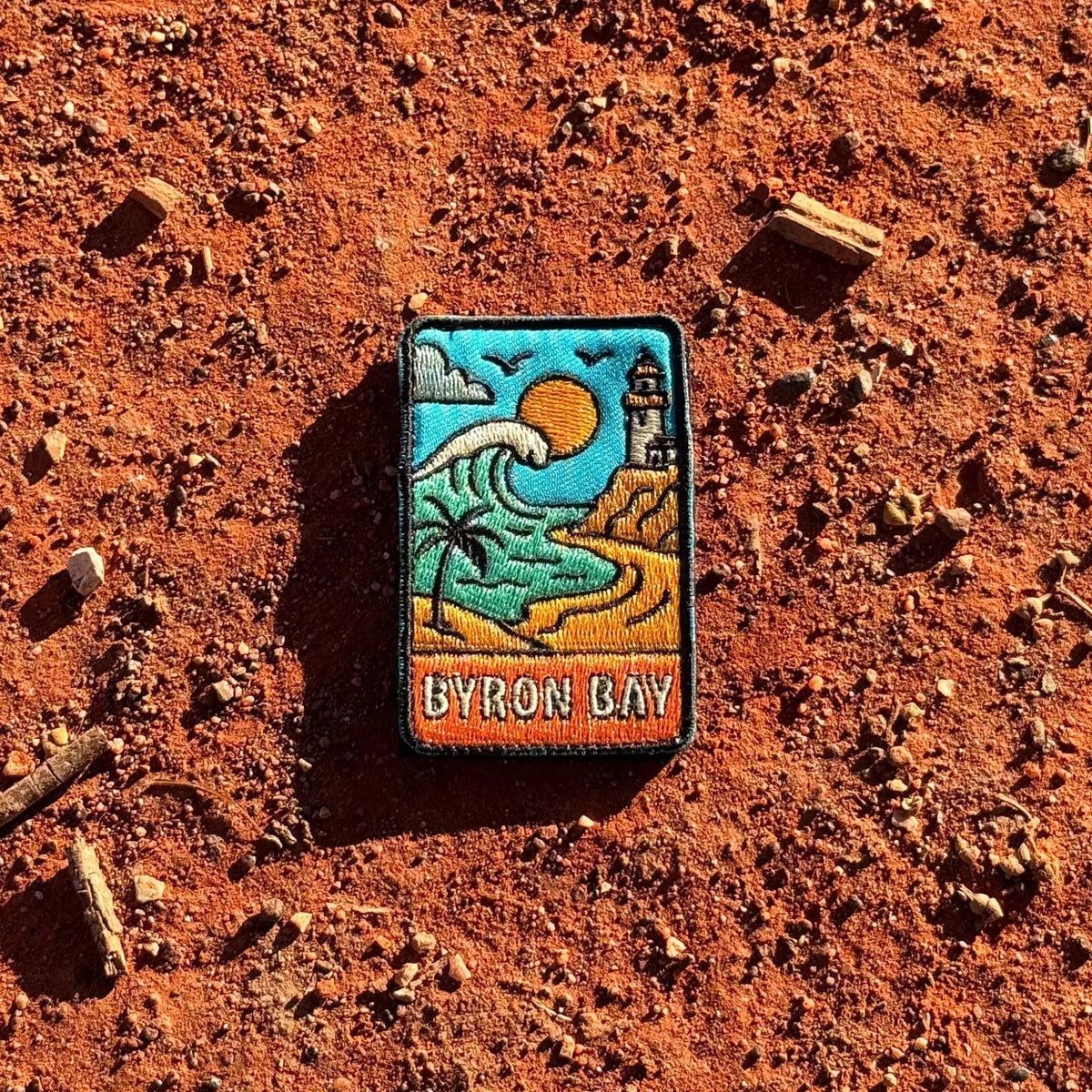 Byron Bay embroidered travel patch with Cape Byron Lighthouse above the coast.