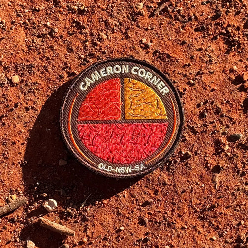 Cameron's Corner embroidered travel patch with a survey marker in the red outback at Cameron Corner.