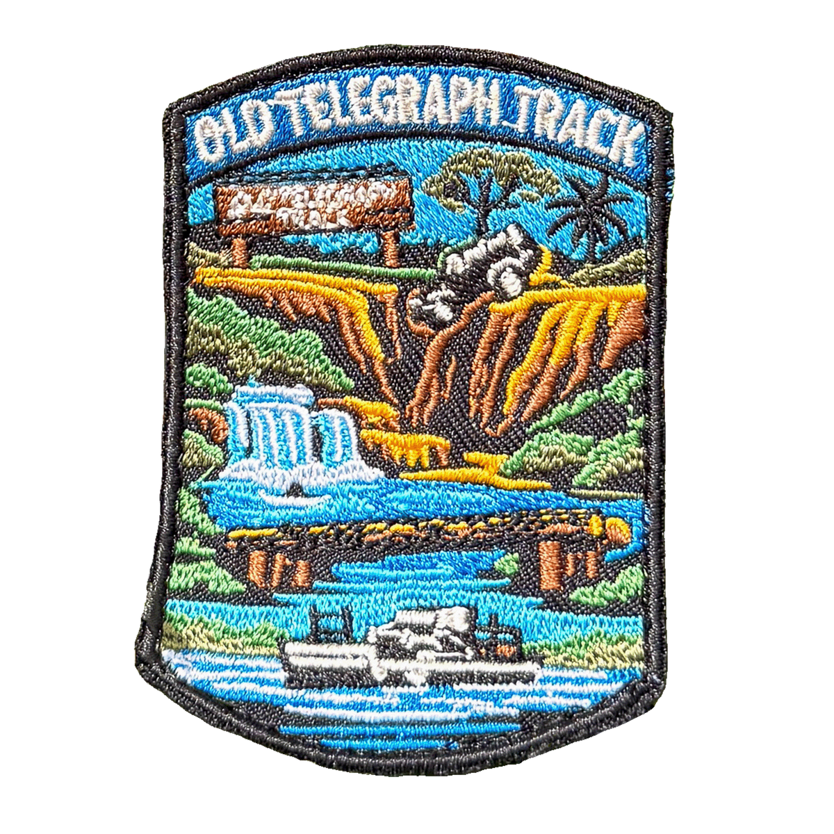 Cape York - Old Telegraph Track embroidered travel patch with a four-wheel drive crossing a creek on the Old Telegraph Track; photographed on a transparent background.