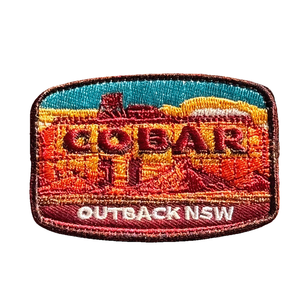 Cobar embroidered travel patch with a mining headframe in a red outback landscape; photographed on a transparent background.