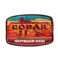 Cobar embroidered travel patch with a mining headframe in a red outback landscape; photographed on a transparent background.
