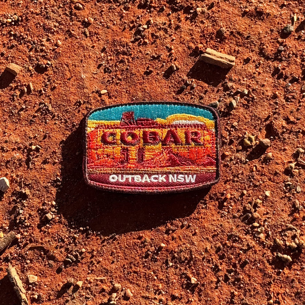 Cobar embroidered travel patch with a mining headframe in a red outback landscape.
