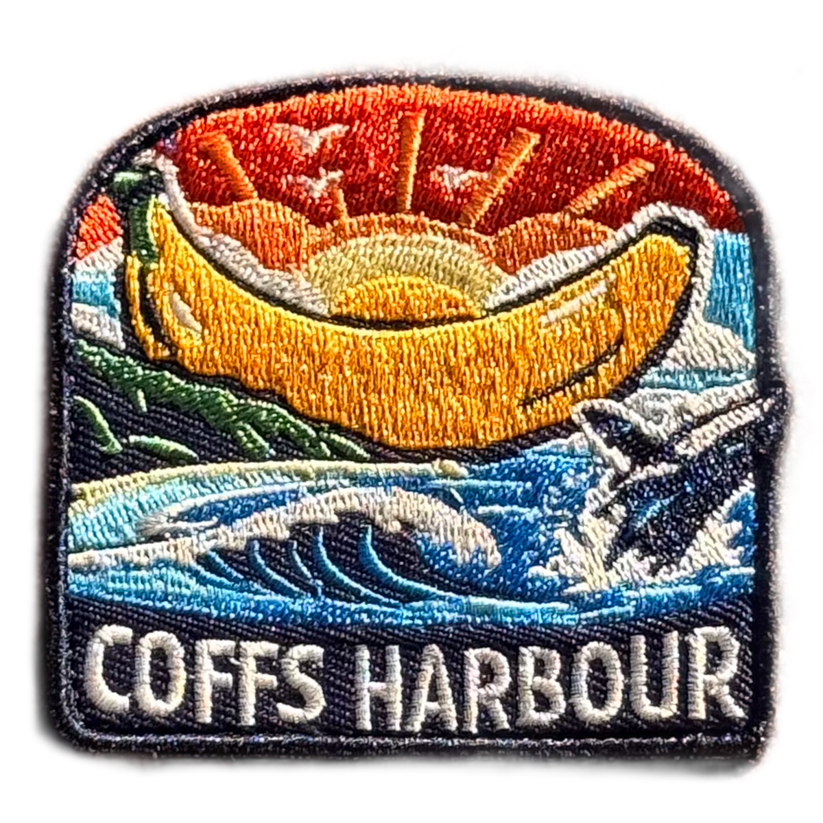 Coffs Harbour embroidered travel patch with the Big Banana landmark; photographed on a transparent background.