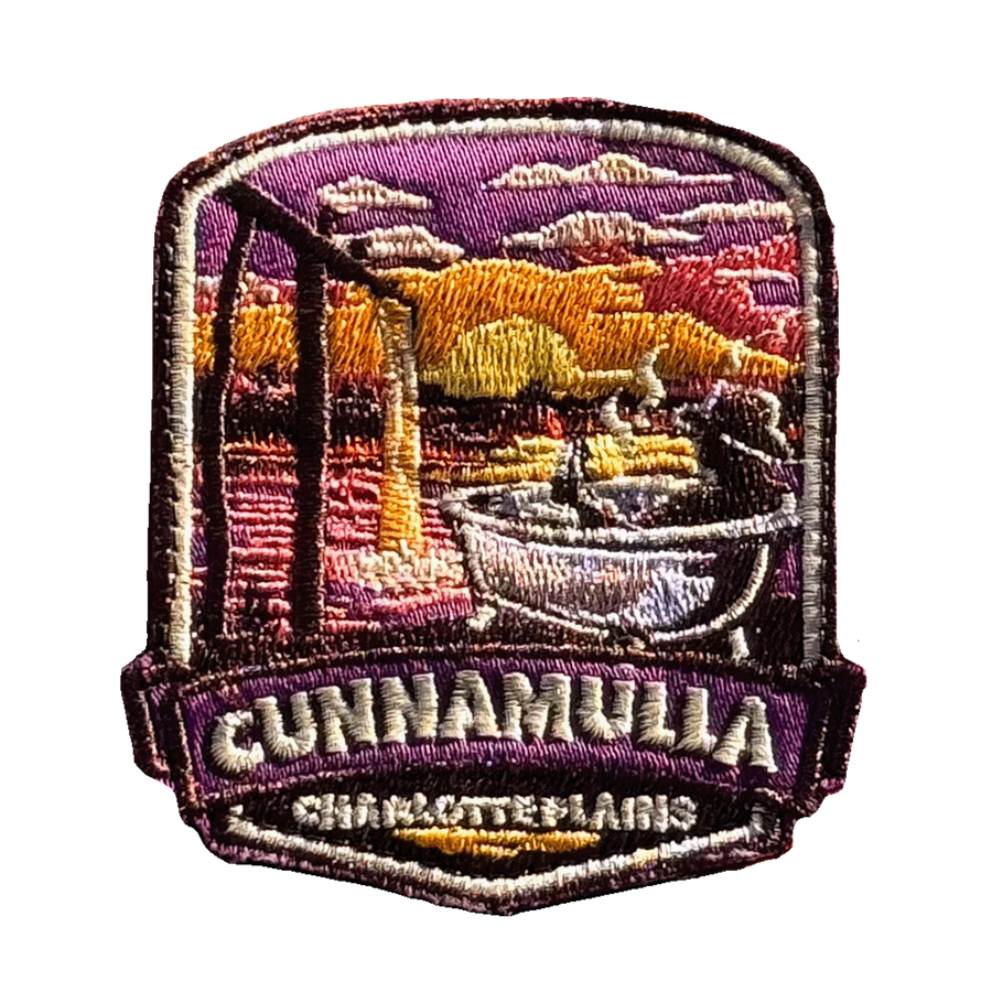 Cunnamulla - Charlotte Plains embroidered travel patch with a person relaxing in an outdoor bath at Charlotte Plains beneath a sunset sky; photographed on a transparent background.