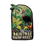 Daintree Rainforest embroidered travel patch with a cassowary surrounded by tropical rainforest, palms and flowers; photographed on a transparent background.