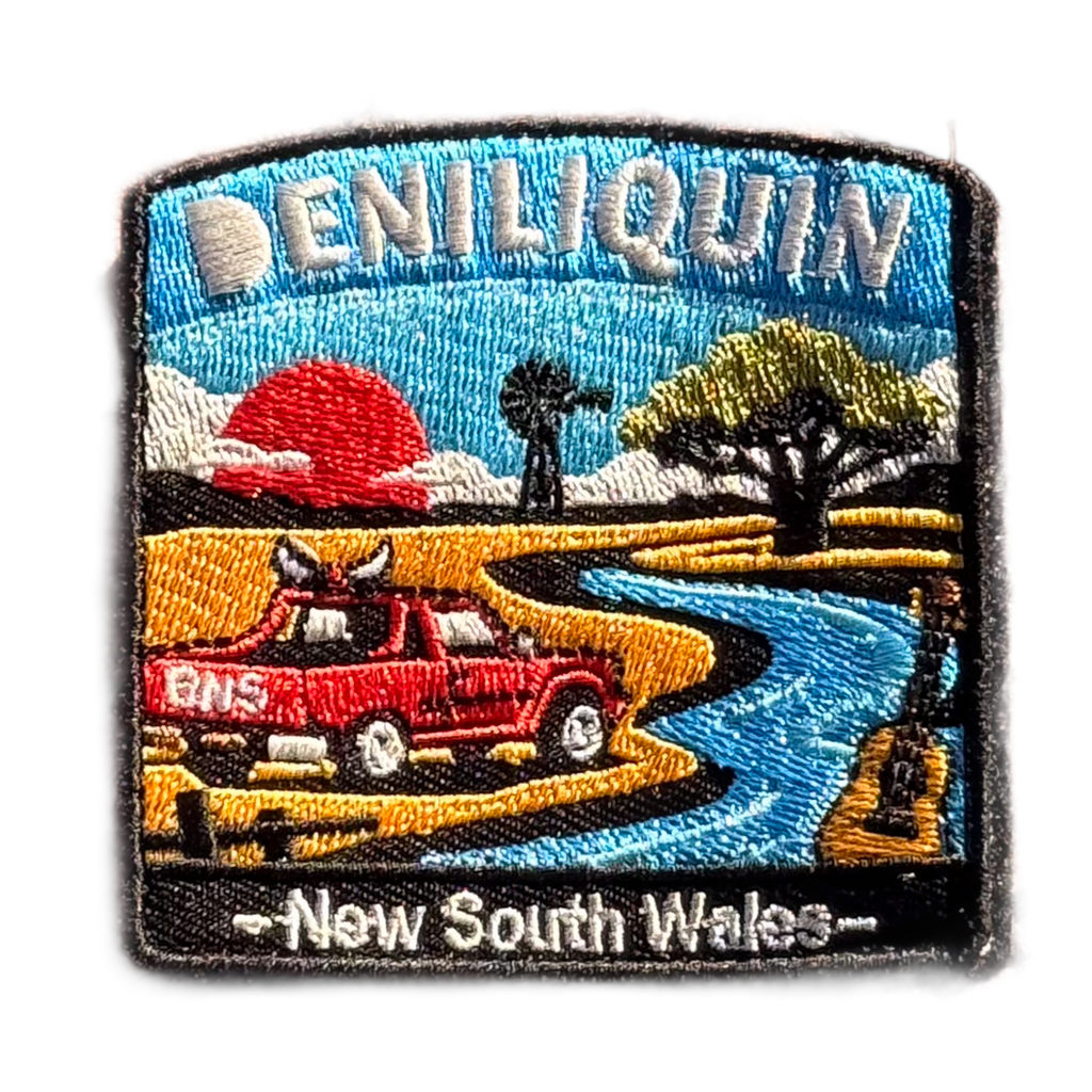 Deniliquin embroidered travel patch with a red ute, guitar, windmill and winding river beneath an orange sunset; photographed on a transparent background.