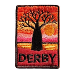 Derby embroidered travel patch with a jetty extending across tidal flats at sunset; photographed on a transparent background.