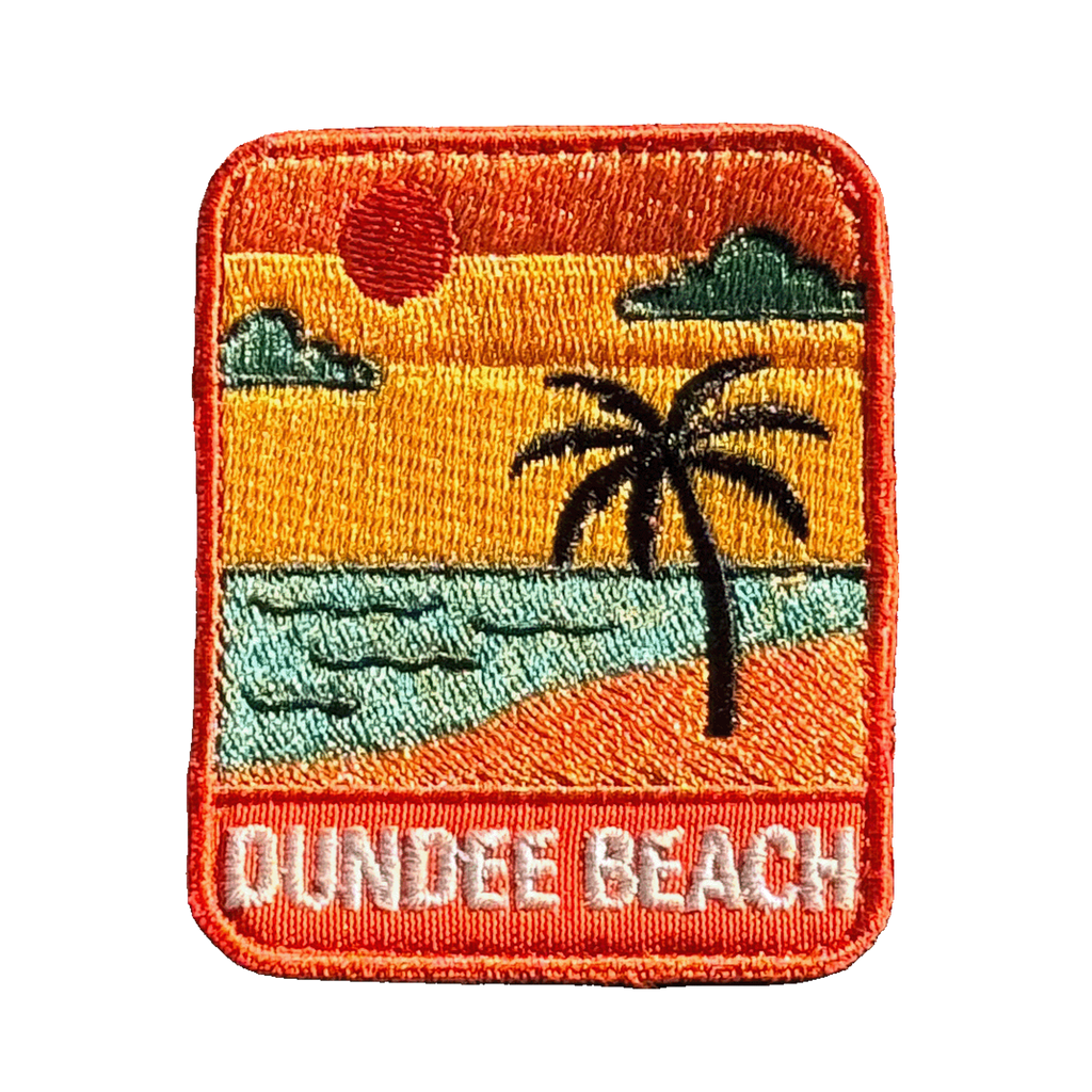Dundee Beach embroidered travel patch with a tropical beach with palm trees; photographed on a transparent background.