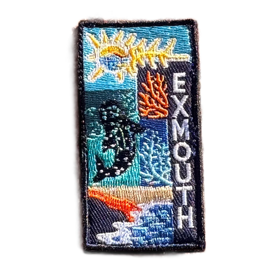 Exmouth embroidered travel patch with a whale shark swimming through blue ocean; photographed on a transparent background.