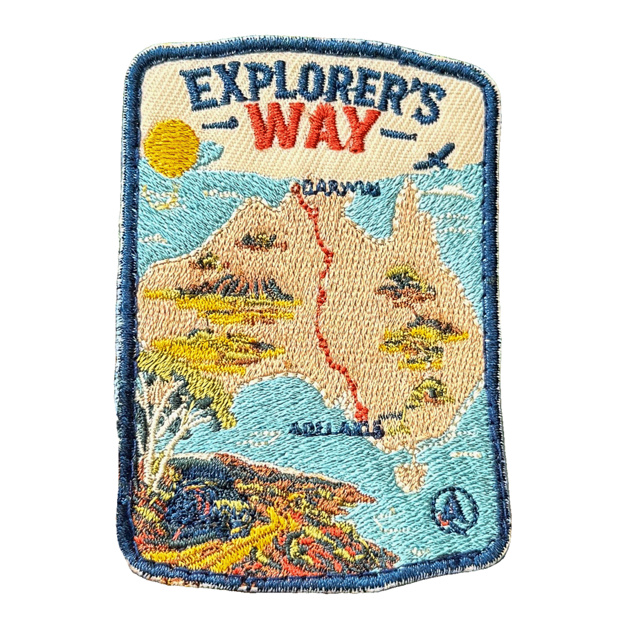 Explorers Way embroidered travel patch with an outback road through red desert country; photographed on a transparent background.