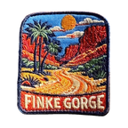 Finke Gorge embroidered travel patch with red gorge walls and desert vegetation; photographed on a transparent background.