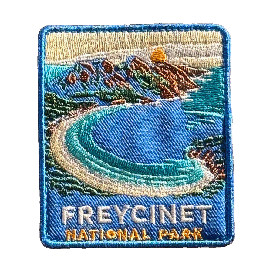 Freycinet - Wineglass Bay embroidered travel patch with Wineglass Bay, turquoise water and granite mountains; photographed on a transparent background.