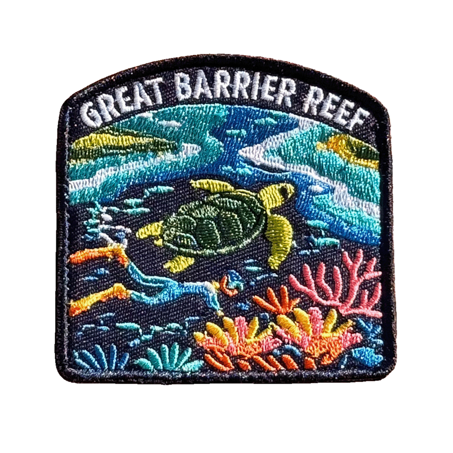 Great Barrier Reef embroidered travel patch with a sea turtle above a colourful coral reef; photographed on a transparent background.